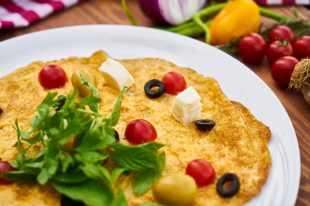 prato de omelete com folhas, queijo, tomate e azeitona