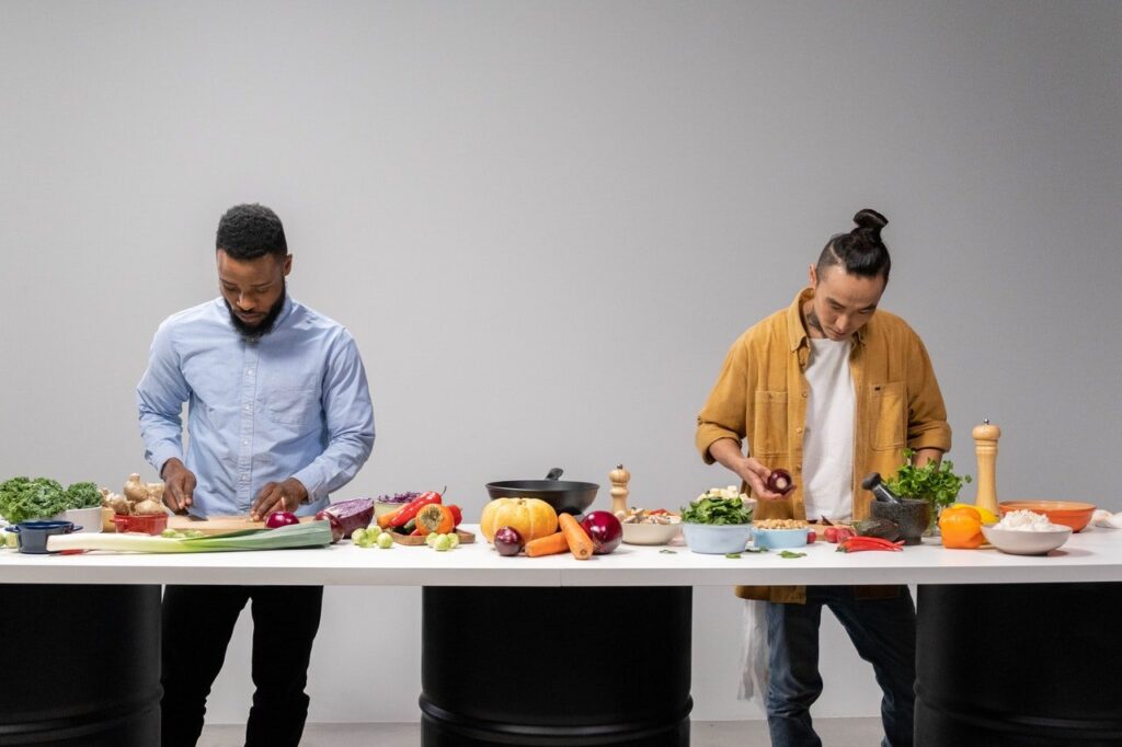 Dois homens preparando receitas para melhorar o colesterol