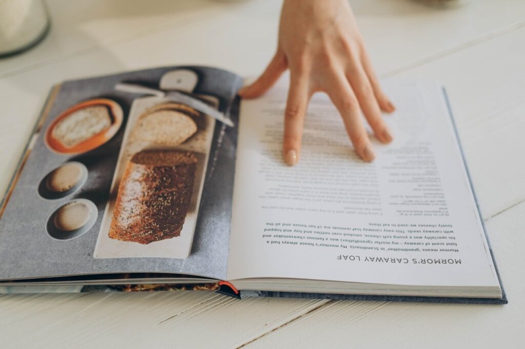 pessoa com livro de receitas na mão aprendendo como ganhar dinheiro na internet com receitas