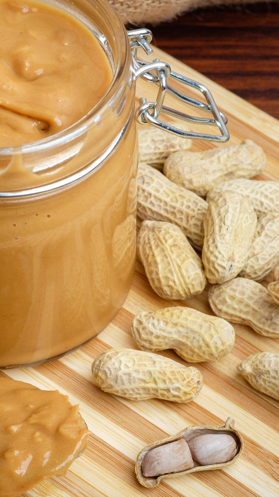 Pasta de amendoim caseira, ao lado de amendoins com casca.