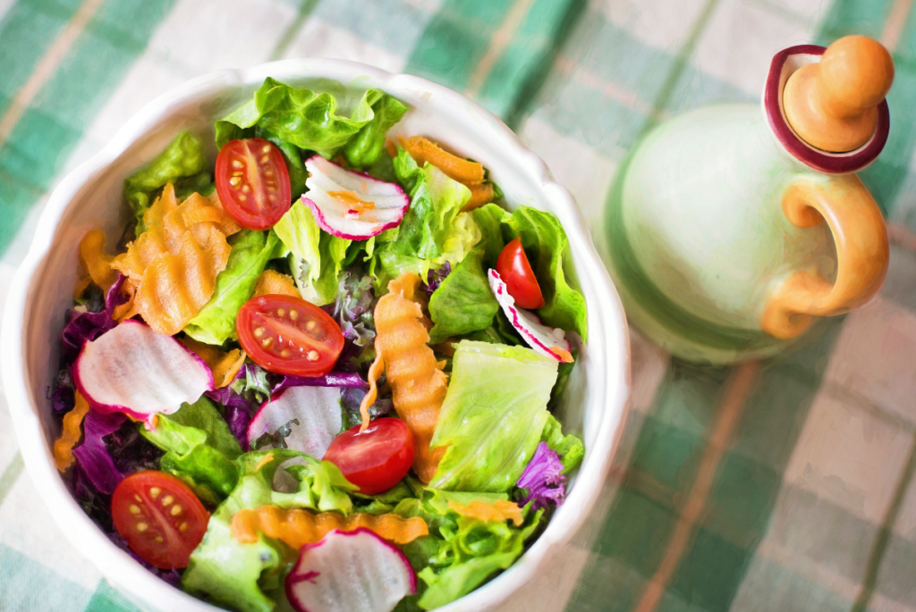 Prato de salada com tempero ao lado