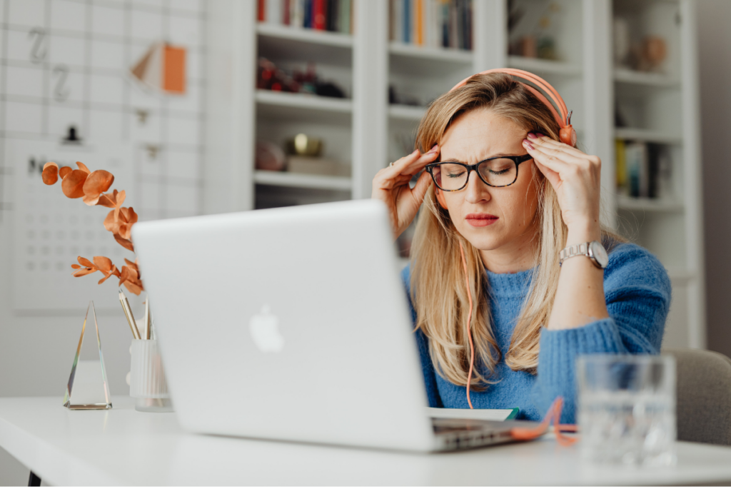 mulher no computador com dor de cabeça