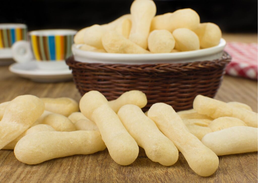 biscoitos doces de polvilho frito em cesta e também em cima de uma mesa