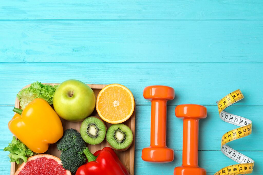 Pesos de ginástica com alimentos diversos em fundo azul