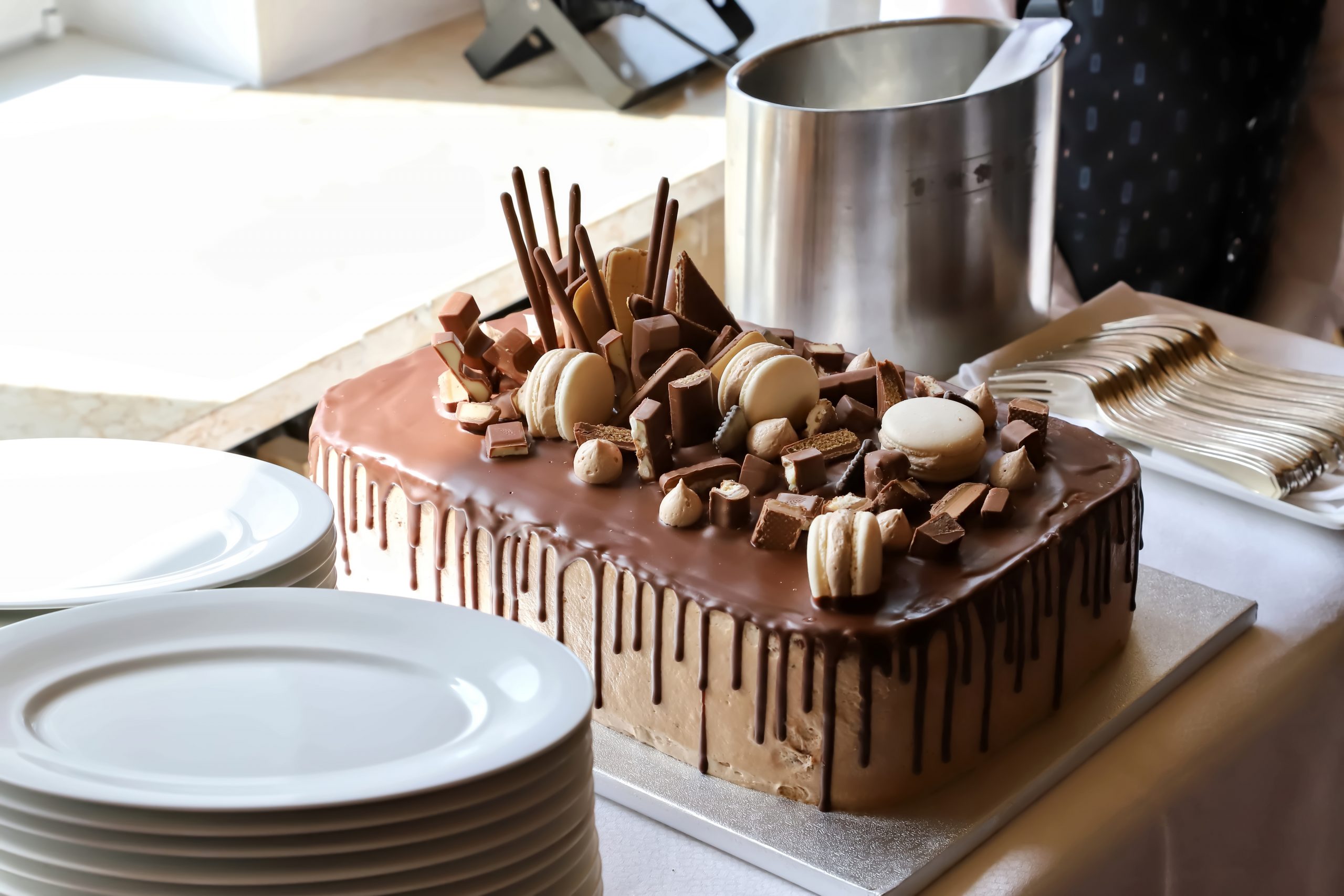 Bolo de chocolate confeitado ao lado de pratos brancos