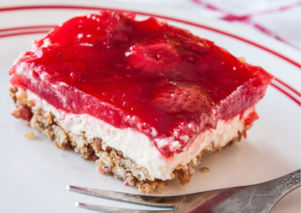 Doce com gelatina em prato branco com garfo ao lado