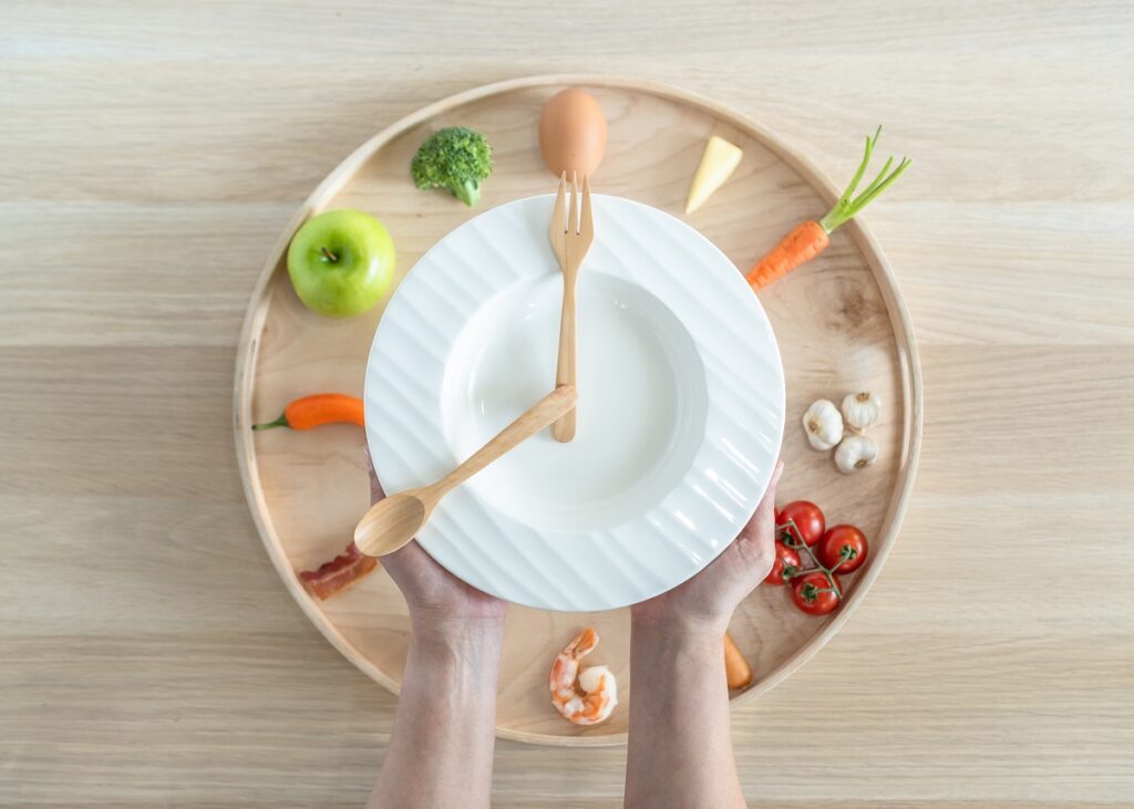 prato de comida branco com garfo e colher imitando relógio em cima