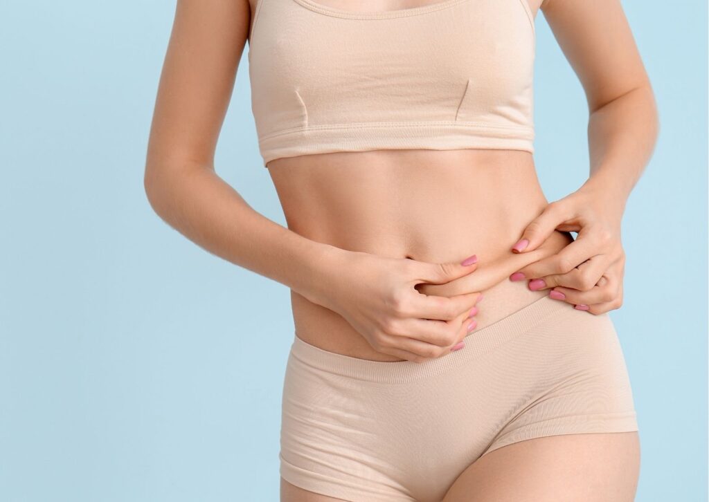 pessoa apertando a própria barriga