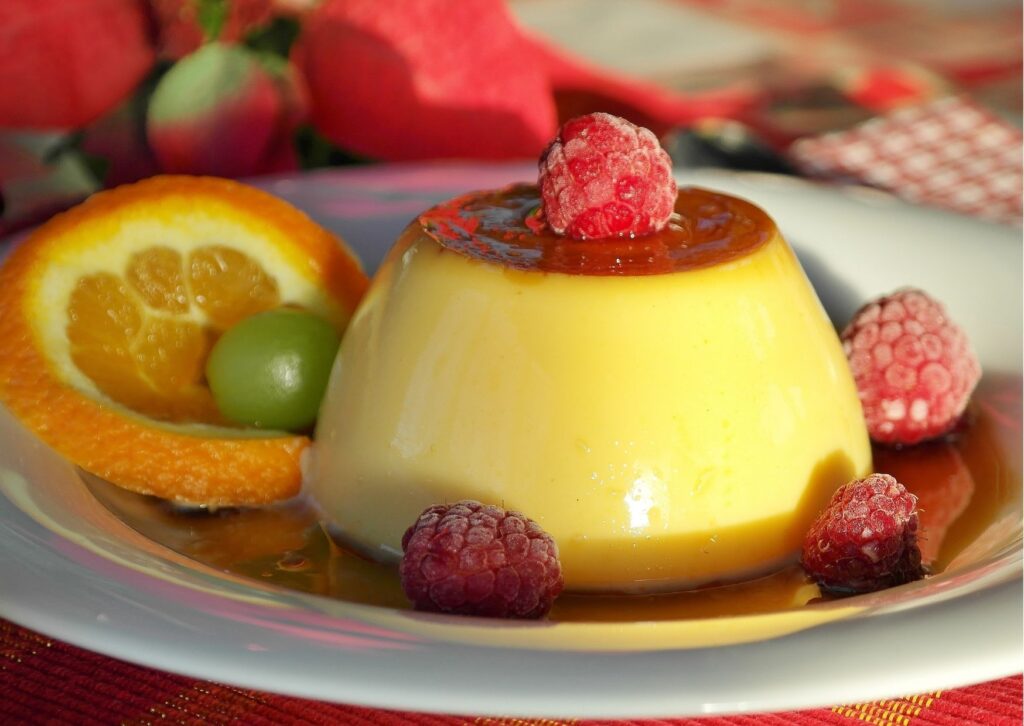 Imagem de mesa posta com uma receita de pudim sem leite com frutas