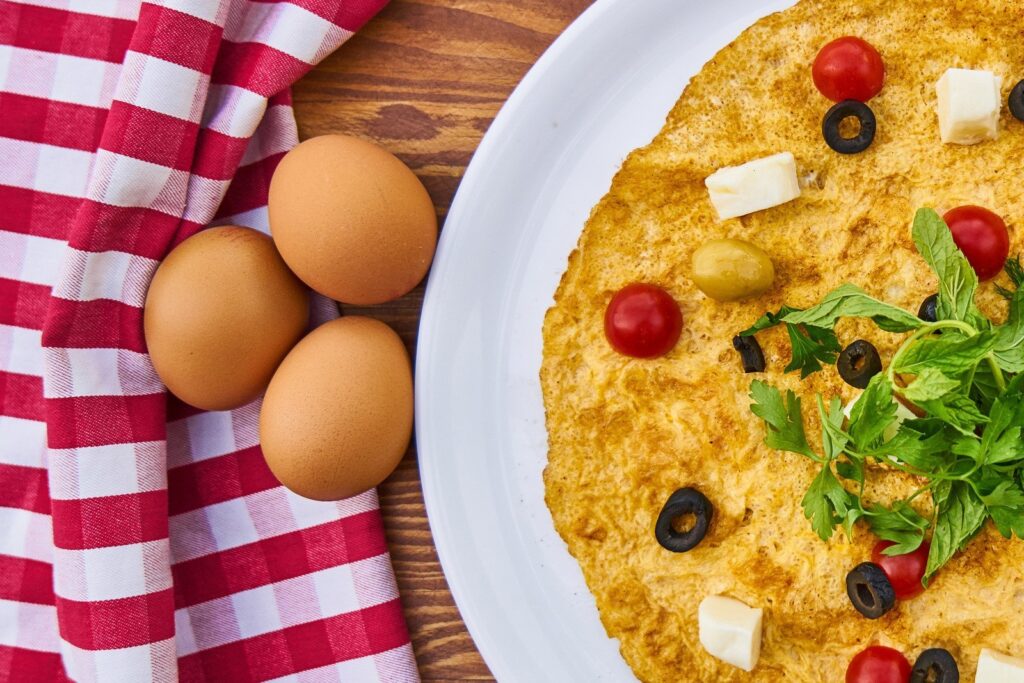 Omelete de forno com ovos ao lado do prato. omelete de forno é uma das receitas para almoço saudável e rápido