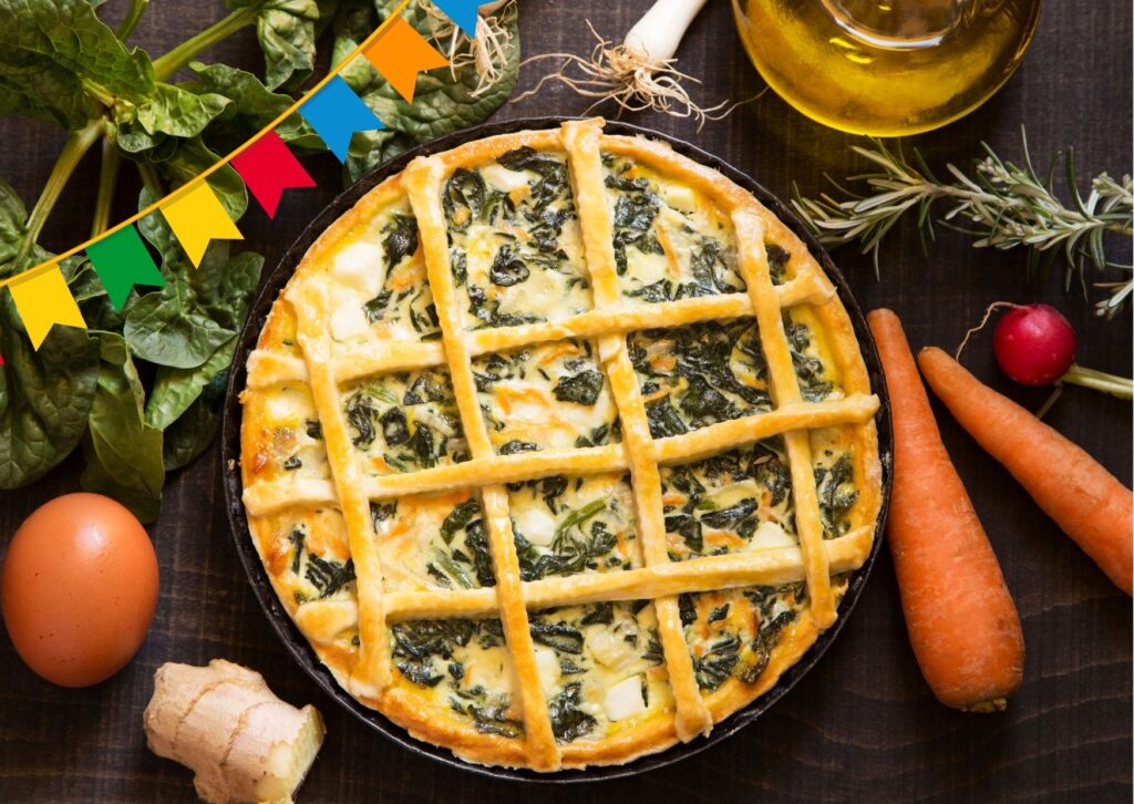 Imagem com fundo escuro com uma torta vegetariana junina