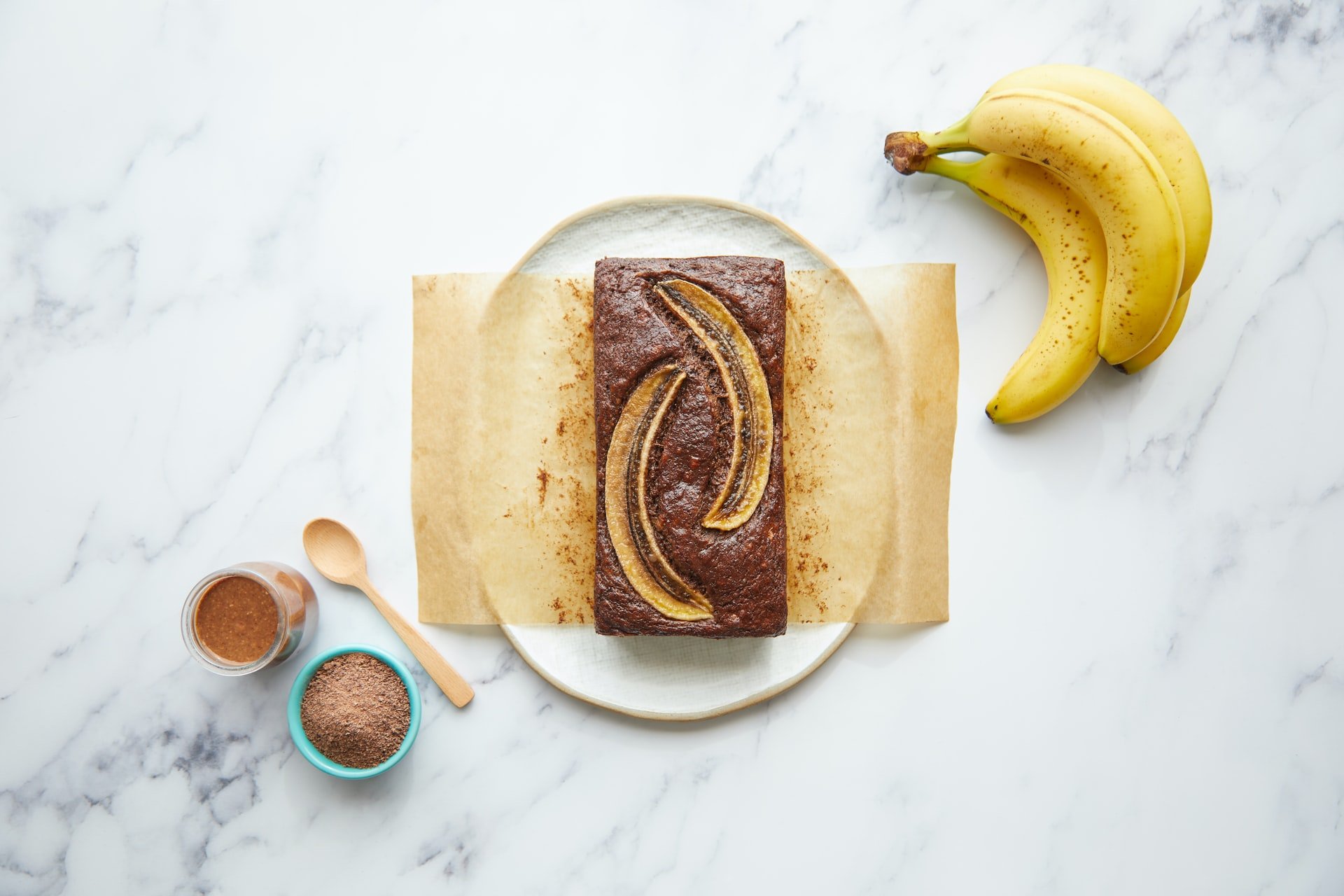 Bolo de banana com bananas e canela ao redor