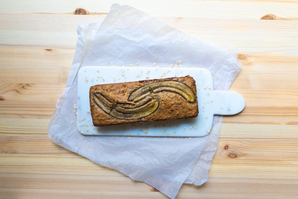 Bolo de banana em cima de tábua branca