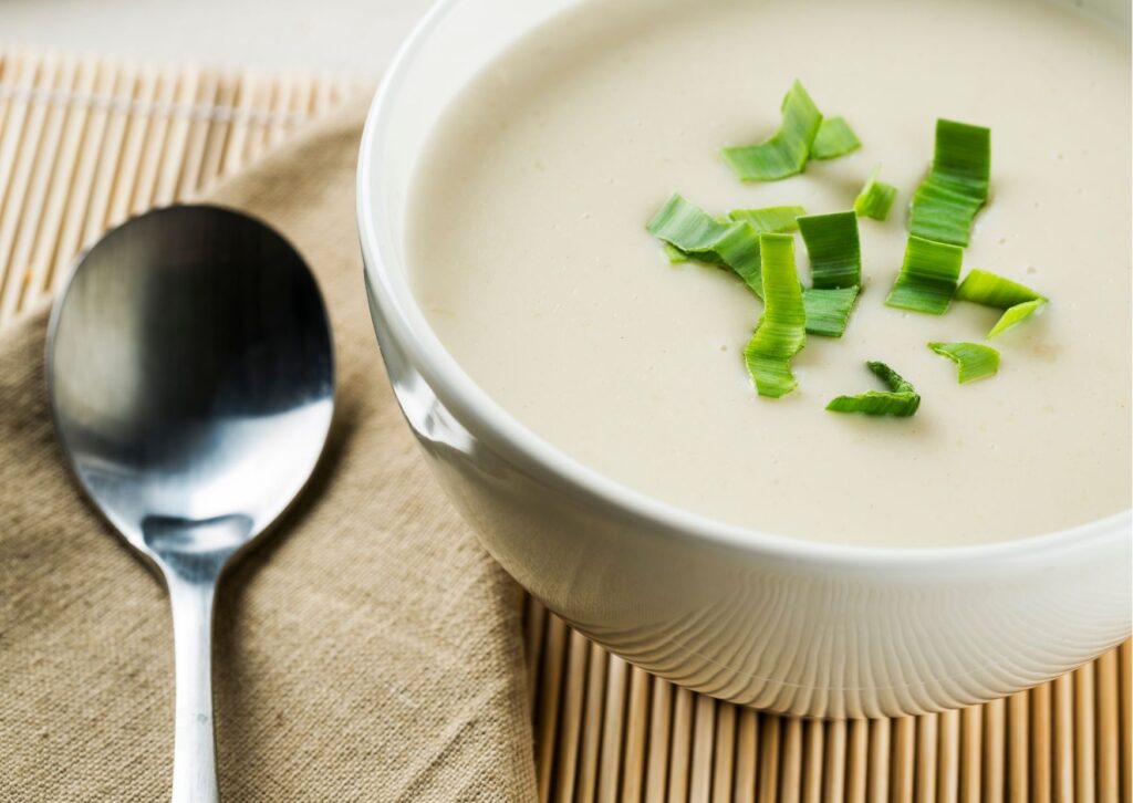 Imagem com uma colher para tomar sopa de alho-poró no pão italiano