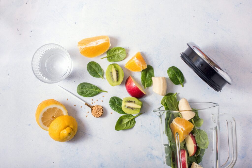 Liquidificador aberto com ingredientes variados em fundo claro