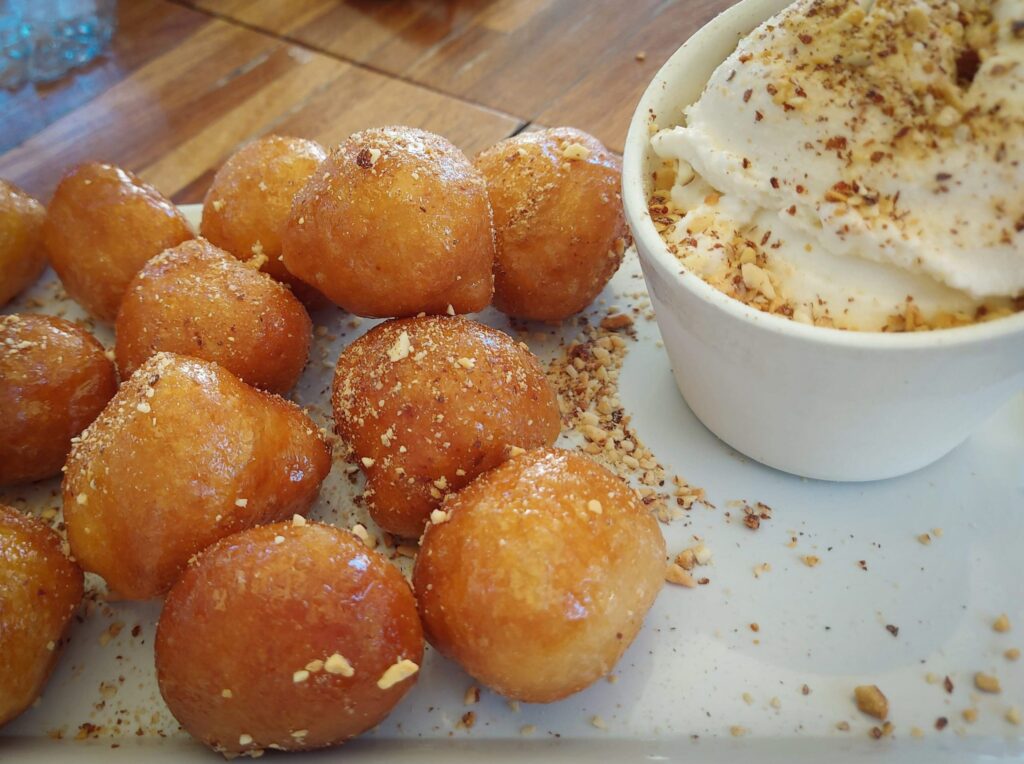 Bolinho leite em pó com massa frita coberta com mel ou açúcar.