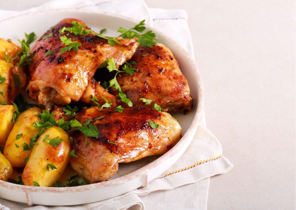 Imagem com frango assado com legumes servido em um prato