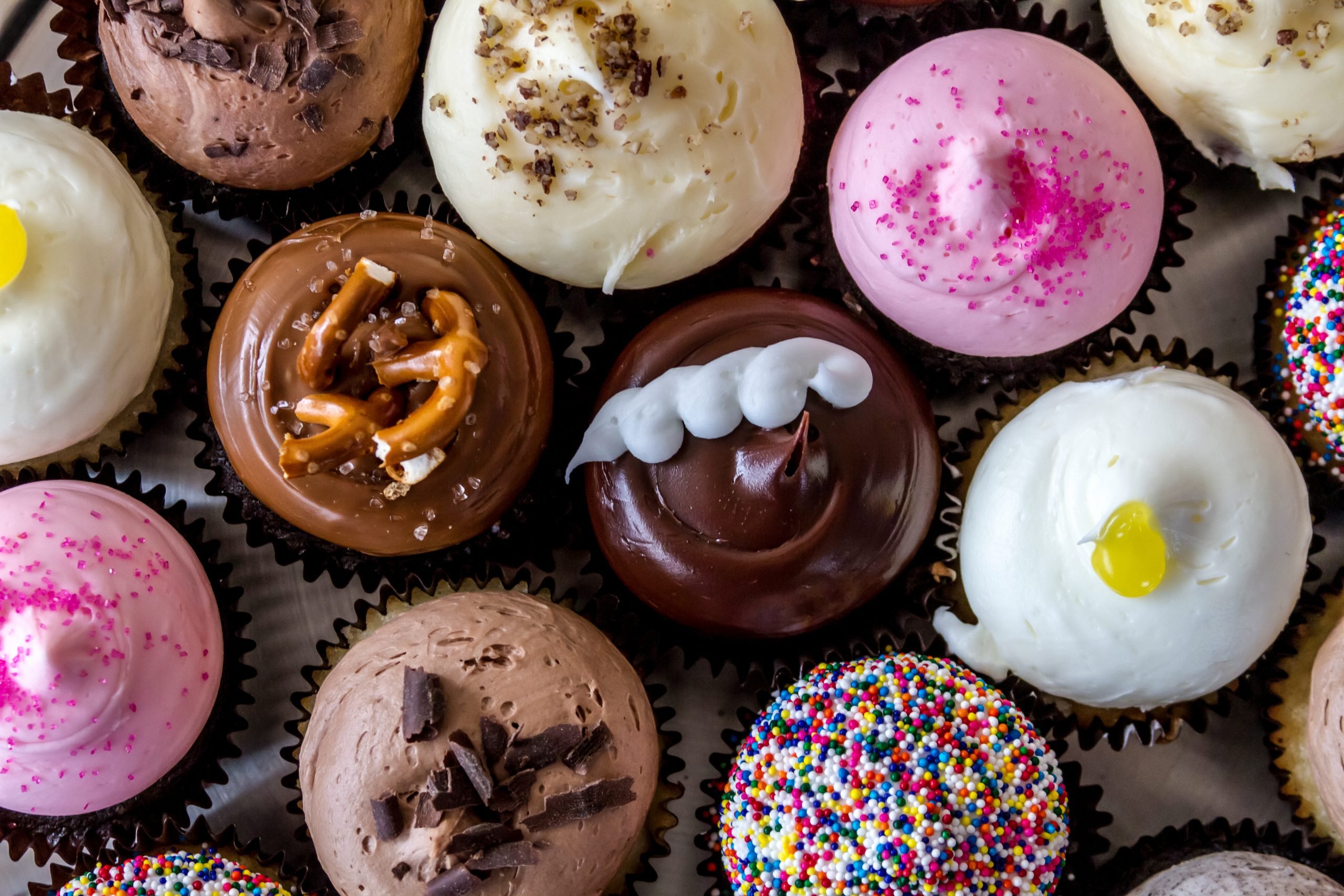 Sabores variados de cupcakes decorados.