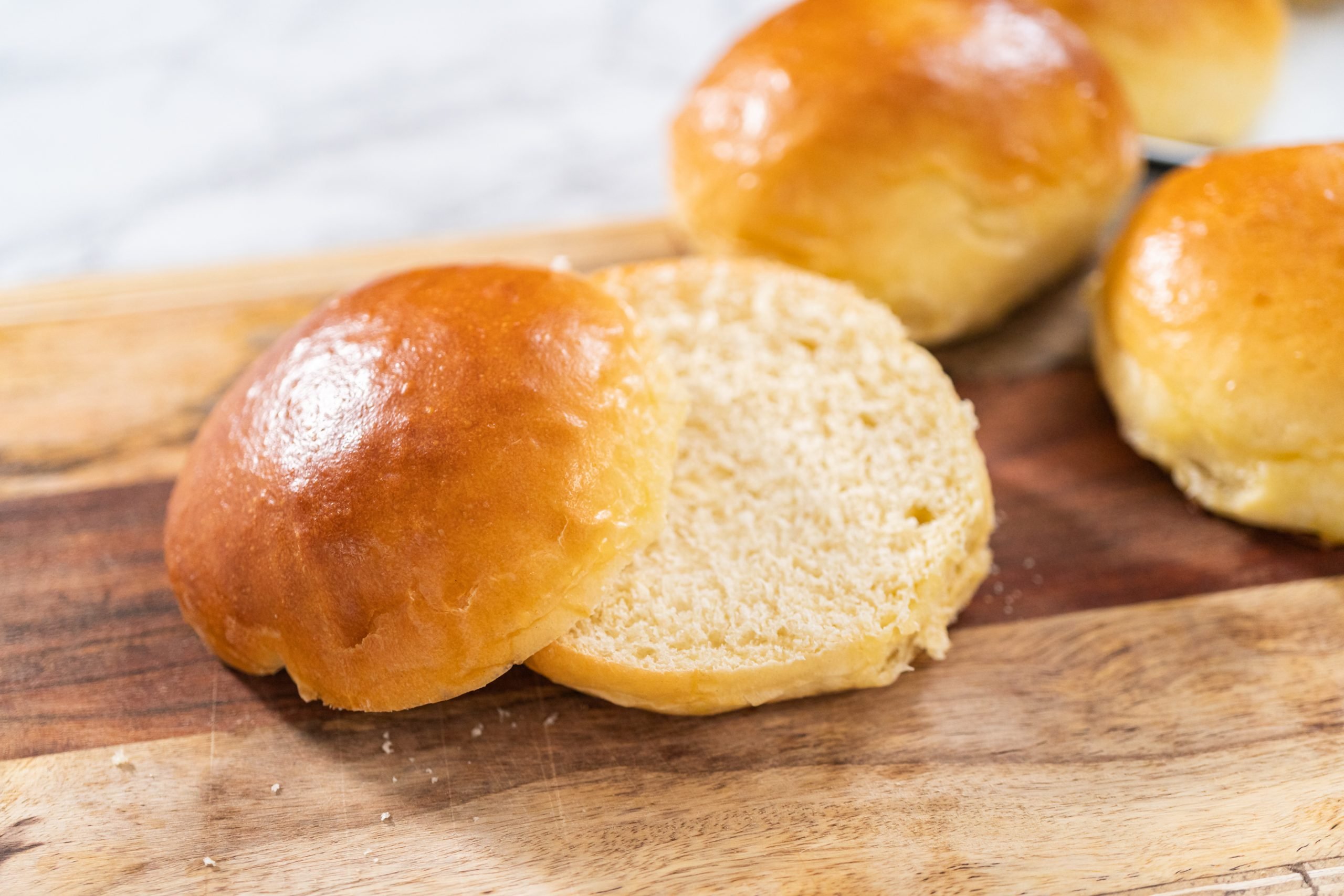 pão de brioche recém-assado em uma tábua de madeira.