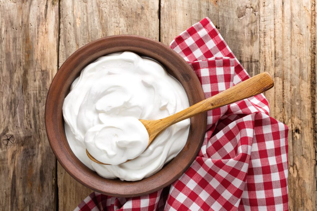 Creme de leite caseiro com toalha xadrez e fundo de madeira.