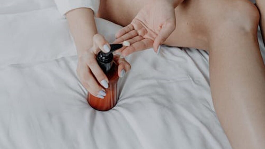 Mulher pegando creme para passar nas pernas