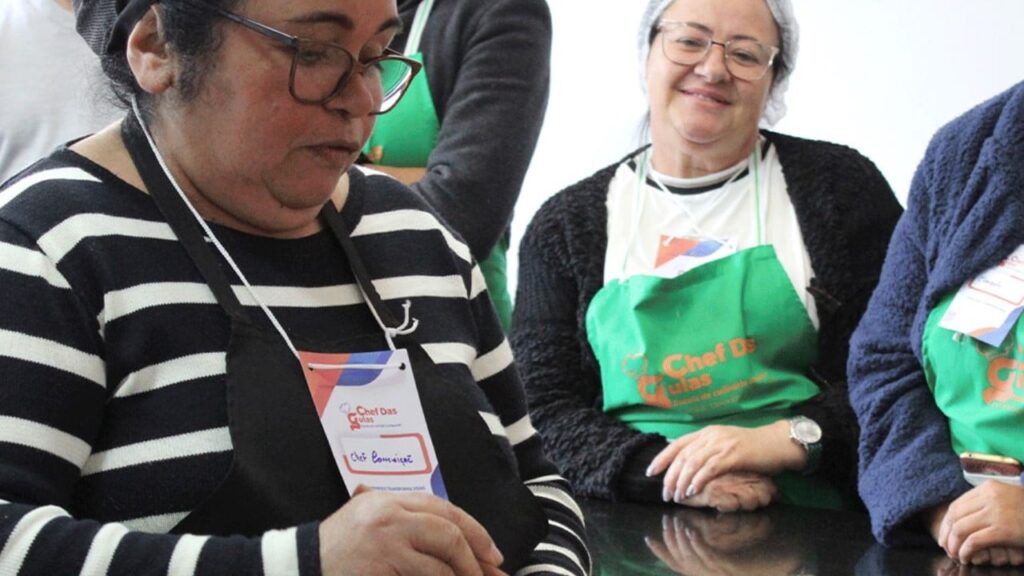 Mulher cozinhando e colega sorrindo