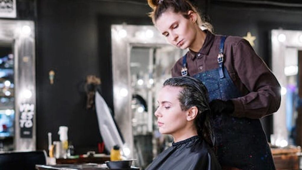 Cabeleireiro fazendo tratamento em cabelo de cliente