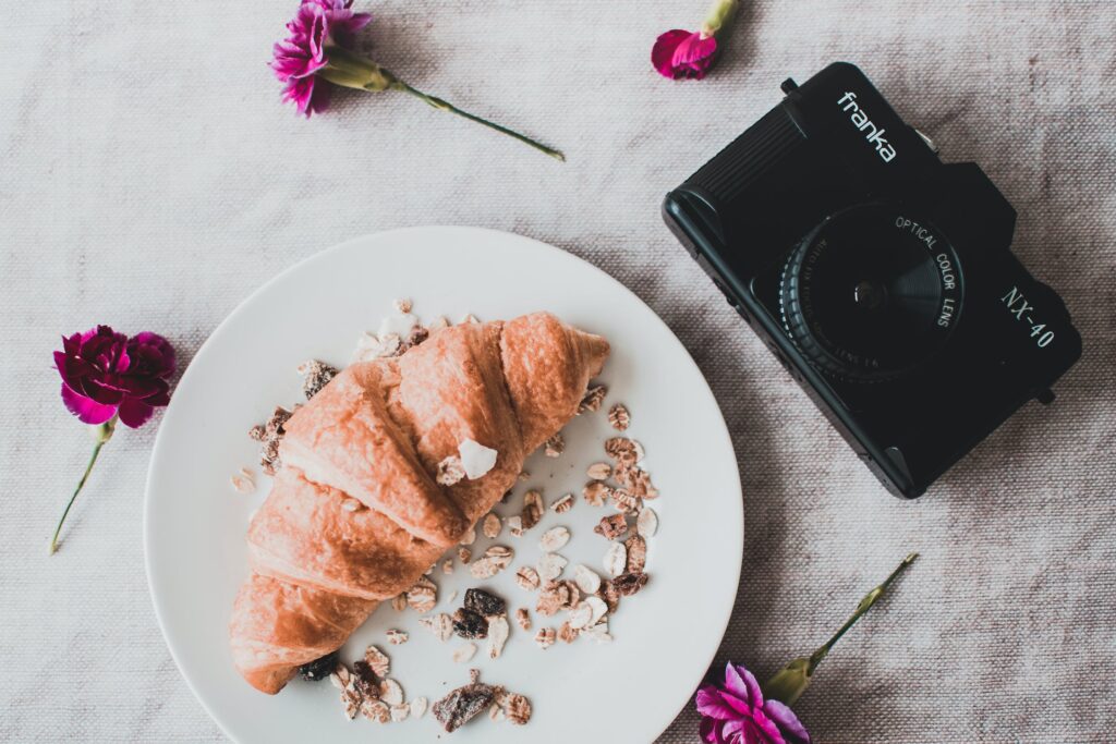Pão visto de cima com aveia e câmera fotográfica ao lado